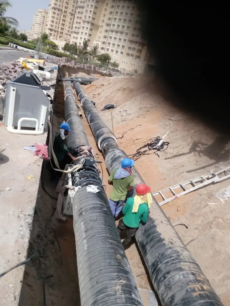"Underground district cooling pipe welding and installation by Popular Power Technical Service team in a UAE urban infrastructure project"